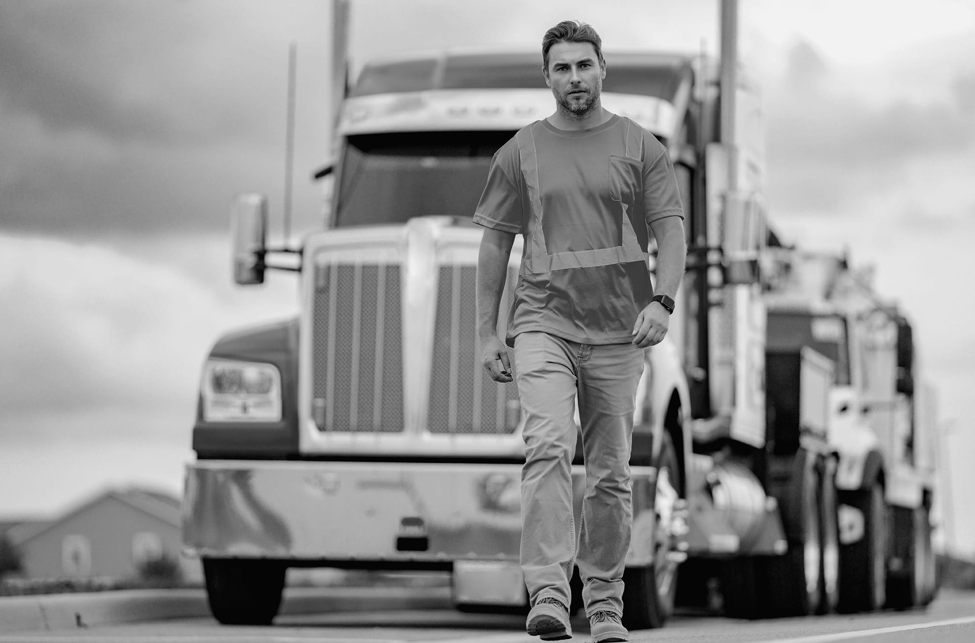 A UGL driver in a safety vest standing confidently next to his tractor